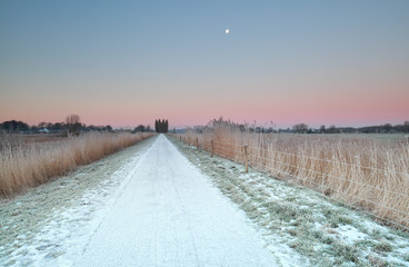 Obraz premium countryside road in snow at sunrise