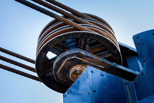 Three cable metal pulley wheel with cables.