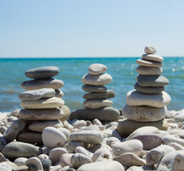 Fototapeta na wymiar Pyramid of pebbles on a sea beach.