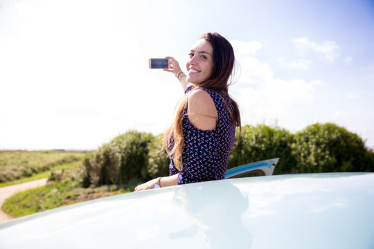 Young woman takes a selfie from a car