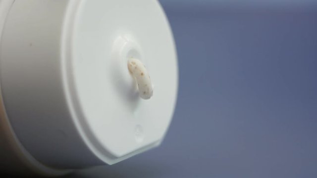 Moisturizing white cream squeezed out of the tube on a purple background. White cream with herbal phyto additives