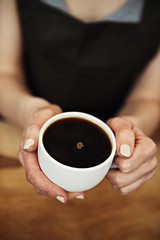 Close-up of female holding fresh coffee mug. Concept of coffee break and relaxation.  
