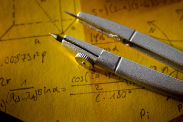 Compass on a notebook with the words geometry
