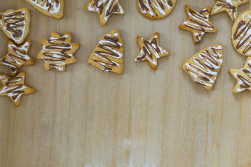 Gingerbread Christmas cookies, on a kitchen table, glazed with chocolate and sprinkled with powdered sugar, diffrent shapes. Concept Christmas.