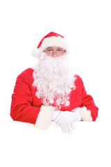 Kind Santa Claus looking out from behind the blank sign isolated on white background with copy space