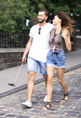 Cheerful young couple walking on urban street