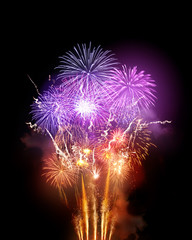 A large bright fireworks display event with golden orange and purple rocket breaks.