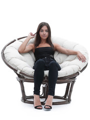 Fototapeta na wymiar young woman sitting in comfortable round big chair