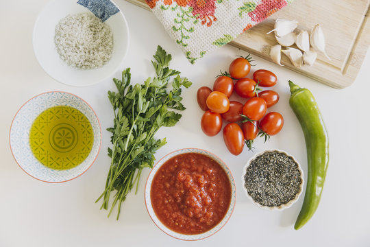 Simple ingredients for basic tomato sauce on a white table