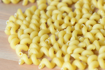 Scattered pasta on a wooden surface close up