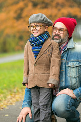 Father and son playing in the park in autumn scenery