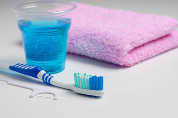 Dental hygiene. Toothbrush, mouthwash, pink towel, dental floss.