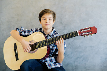 Teen boy playing acoustic guitar