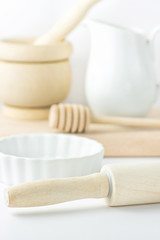Baking Essentials Utensils on White Tabletop Bowl Wood Rolling Pin Honey Dipper Jug Cutting Board. Holiday Christmas Easter Baking. Kitchen Interior