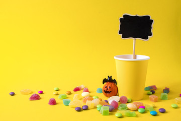 Obraz premium drink cup paper with pumpkin decoration and wood banner tag with colorful candy