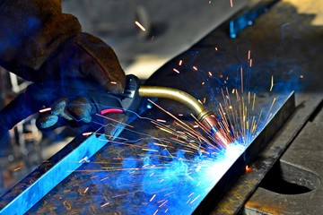 Industrial Worker labourer at the factory welding steel structur