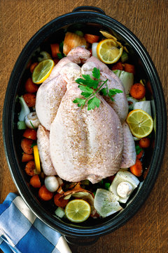 Whole chicken in roasting tin with veg ready for the oven.
