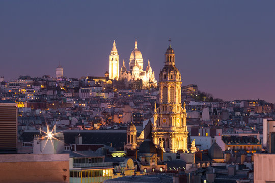 Fototapeta Aerial view of Sacre-Coeur Basilica or Basilica of the Sacred Heart of Jesus at the butte Montmartre and Saint Trinity church at night, Paris, France