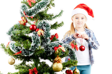 Studio portrait of little girl decorating Christmas tree