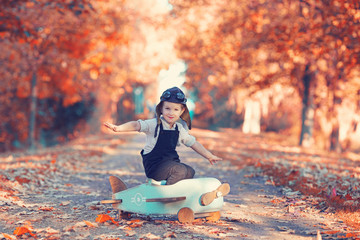 Junge fliegt durch den bunten Herbstpark