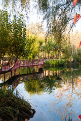 Naklejka premium Red Bridge and Gazebo by a Pond