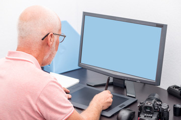 Fototapeta na wymiar mature man working with graphics tablet in his office