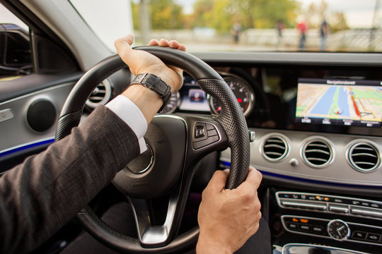 Closeup of man driving a car holding steering wheel