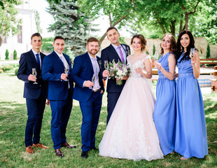 Newlyweds and their friends pose with glasses of champagne in the garden