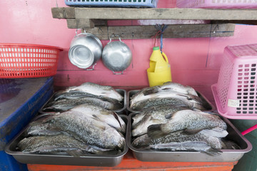 White snapper prepare for cooking by street food with colorful local store.