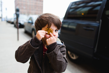 boy puts cookie over one eye