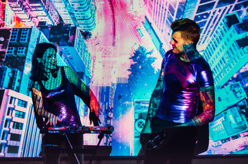 the girl with the guy in the background of the projector screen . Love couple DJs and play music ....