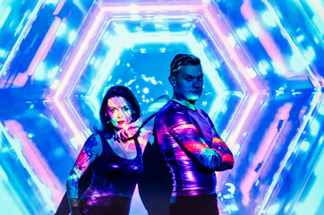 the girl with the guy in the background of the projector screen . Love couple DJs and play music . Festive disco