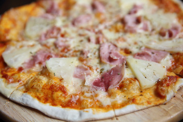 pizza hawaiian , pizza with pineapple and ham with cheese and tomatoes sauce on wood background , italian food
