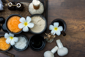Fototapeta na wymiar Thai spa composition treatments aroma therapy with candles and Plumeria flowers on wooden table close up. Healthy Concept.