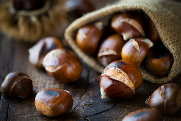 Roasted chestnuts on dark rustic wooden background