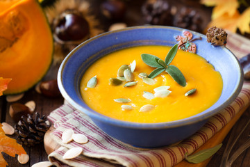 Creamy Pumpkin soup or squash soup with garnished with pumpkin seeds and sage leaves
