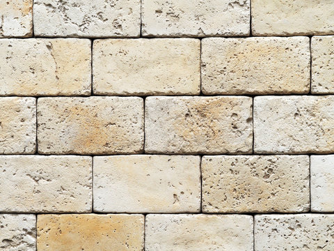 Wall of stone frayed blocks, stone texture, masonry of irregular light beige color