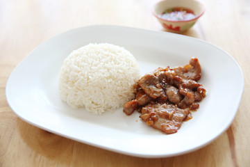 fried pork with garlic and rice on wood background , Thai food
