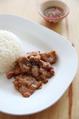 fried pork with garlic and rice on wood background , Thai food