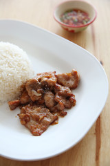 fried pork with garlic and rice on wood background , Thai food