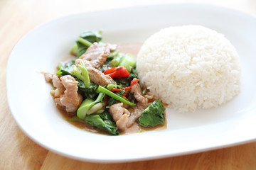 fried pork with Chinese Kale and rice on wood background , Thai food