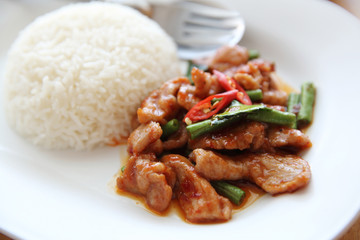 fried pork with thai curry and rice on wood background , Thai food