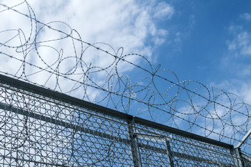 Border fence closeup with wire mesh closeup on blue sky background