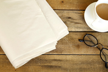 Newspaper with coffee on wooden table