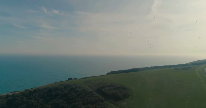 Aerial view of paragliders at Beachy Head, Southern England, with the sea in the background