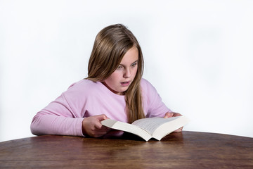 shocked little girl with a book on a white background