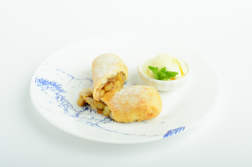 Apple strudel with ice cream decorated mint on a plate isolated on white background