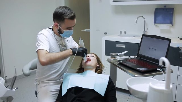 dentist in the dental office communicates with the patient and laughs