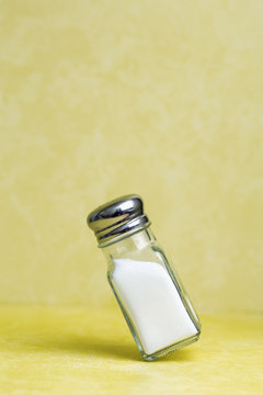 Salt shaker balanced on its edge