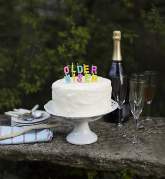 Older wiser written with candles on top of frosted cake